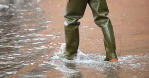 Close Up of legs with boots due to the high water. This flood happens when there is high tide in Venice, Italy.